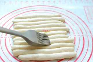 把每一个小剂子揉搓成长条，表面刷上一层食用油，盖上保鲜膜，静置醒发10分钟，让面团彻底松弛，这样容易造型，面团在搓麻花的过程中不会断裂。