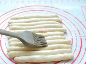把每一个小剂子揉搓成长条，表面刷上一层食用油，盖上保鲜膜，静置醒发10分钟，让面团彻底松弛，这样容易造型，面团在搓麻花的过程中不会断裂。