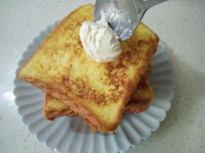 淡奶油加糖打发，用勺子放在土司顶部，淋少许蜂蜜，装饰草莓即可。
煎土司时要小火，多检查底部，防止煎糊。