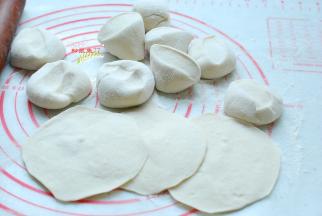 这时候的面团也已经发酵好了，面团发酵至两倍大取出来，揪下一块面团，搓成长条，做成小剂子，按扁擀成圆形的包子皮。