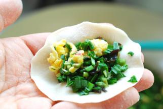 取一个饺子皮放在左手上，再放入适量的饺子馅，两手配合捏成好看的饺子。素馅比较散，用小勺子放馅，很方便，你可以试一试哦！