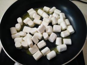 无盐黄油切成小丁后放进不沾锅里，小火融化，做雪花酥必须一定要用不粘锅，不然后面会粘得一塌糊涂，倒入棉花糖开始小火炒。