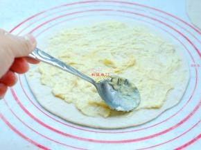 用小勺子把榴莲肉在小碗内加一点点盐压烂，然后均匀地涂在擀好的饼上，避开四周。加一点盐可以更好地突出榴莲的甜味。