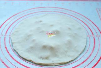 把另外一块面团揉匀，擀成一样大小的薄圆片，盖在榴莲芝士上面，将两块面饼的四周捏紧，防止烙的时候爆开。