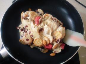 倒入混好的饼干和坚果，关火，继续翻炒均匀。