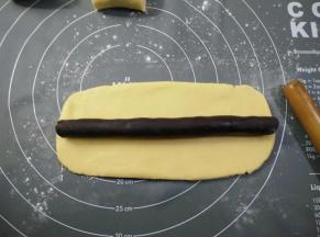 取一份面团擀长，豆沙也搓成长条，放在面团中间，捏合收口稍微搓动一下，使面皮厚度均匀。