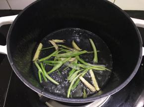 珐琅锅里放一大勺油，入葱段和姜丝爆香。