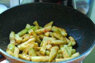 这时候的茄子已经腌制好了，取出来挤干水分，直接放进炸过土豆条的锅里，开小火慢慢煸炒出茄子的水分。茄子经过腌制已经不吸油了，小火慢慢把水汽煸炒出去的同时，茄子也变软了，这样的茄子才会软烂好吃。