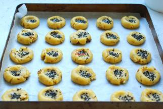 用大拇指粘上黑芝麻，分别在每一个小圆球上面按一下，这样就成了核桃酥的坯子，黑芝麻也不容易掉落。现在开始预热烤箱吧，上下火160度预热15分钟后，把烤盘放进去，烘烤18分钟就好了。烤制期间最好留在烤箱前随时观察，如果在10分钟的时候已经上色明显，那就是温度过高了，如果你的烤箱温度过高，要随时调整。烘烤温度正确的核桃酥只是在表面稍微有点淡淡的黄色，并不是很明显，但是味道会非常香。