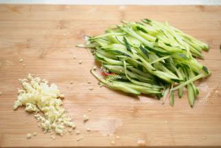 合理安排好时间，你就是时间的强者。粉丝浸泡期间，我们开始制作调料。大蒜3瓣去皮洗净剁成蒜蓉，黄瓜去掉外皮，清洗干净，切成细丝。当然，如果刀工不好借助工具擦成丝也是可以的。