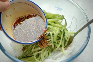 放入切好的黄瓜丝，再把刚才调好的料汁浇上去，用筷子搅拌均匀，放上适量熟的碎花生，就可以开吃了。