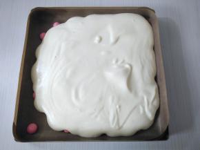 待烤盘不烫手时,把蛋糕糊倒入烤盘（可以将少许蛋糕糊装入裱花袋，围绕粉色波点挤一圈防止有气泡），表面刮平，轻震模具震出气泡。