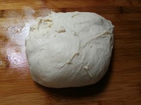 在面包机程序剩余一小时五十分钟的时候，取出面团放在抹油的砧板上