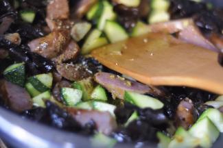 翻炒至西葫芦表皮变为翠绿色， 加入木耳、盐、味精、五香粉等