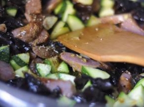 翻炒至西葫芦表皮变为翠绿色， 加入木耳、盐、味精、五香粉等
