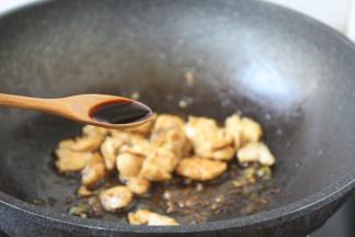 放入少许白胡椒粉，沿锅边烹入1小勺的料酒，放入1勺的酱油，翻炒均匀。