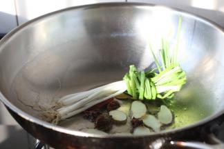 锅烧热，放入2勺的油，油微热时放入小香葱、姜、草果、干辣椒，煸炒至出香味。
