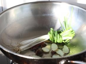 锅烧热，放入2勺的油，油微热时放入小香葱、姜、草果、干辣椒，煸炒至出香味。
