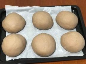 然后烤盘上放上油纸，面团放在烤盘上进行二次发酵50分钟。