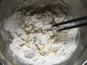 盆中倒入面粉、糖、盐，搅拌均匀后倒入酵母水，再次用筷子搅拌均匀；