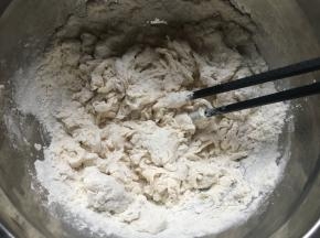 盆中倒入面粉、糖、盐，搅拌均匀后倒入酵母水，再次用筷子搅拌均匀；
