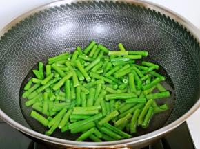 锅中加入水烧开，下豇豆，滴入食用油，大火焯水2分钟，捞出过冷水。