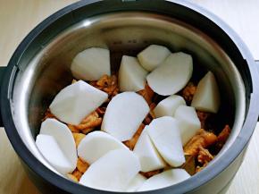 把切好的白萝卜摆放在鸡块上面。