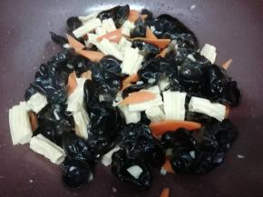 在放入焯好的黑木耳翻炒均匀