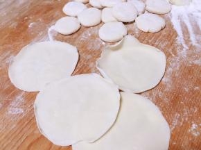 压扁，擀成中间厚边缘薄的面皮