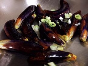 小火慢慢煸炒茄子，使茄子炒软，放入葱碎继续翻炒，这个过程大约需要10分钟
