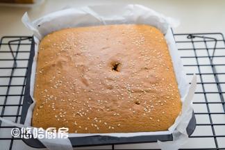 到时间后，用牙签插一下，拔出牙签看带出的蛋糕不发黏即可取出。牙签太短，不小心用手碰到蛋糕，哈哈，表面戳了个洞。提着油纸取出蛋糕放网架上，剥开油纸的四周散热放凉。