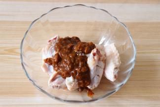 将鸡翅中放入碗里，倒入豆瓣酱；