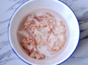 将虾放入冷水解冻，然后用厨房纸拭净水份，加盐、料酒、生粉，搅拌腌制