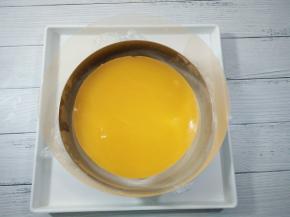 放入7寸慕斯模具中间，上面放入冷冻好的橙子夹心，用小抹刀四周划一圈，脱离慕斯圈。