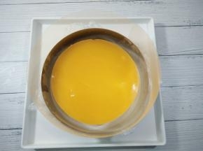 放入7寸慕斯模具中间，上面放入冷冻好的橙子夹心，用小抹刀四周划一圈，脱离慕斯圈。