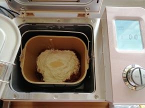 把冰水、糖和盐都倒入面包桶里，再倒入可可粉和面粉，在面粉顶端加上酵母，把面包桶放入到东菱JD08面包机里