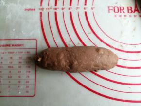 从上往下卷起，下端压薄，卷成橄榄形，捏紧收口处