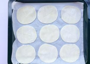 饺子皮摆在铺好油纸的烤盘中。