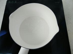 接下来制作焦糖酱，锅中放入水和白砂糖，放电磁炉上用中小火慢慢熬，可以看到锅中慢慢的开始翻白色透明的大泡泡，中途无需搅拌。