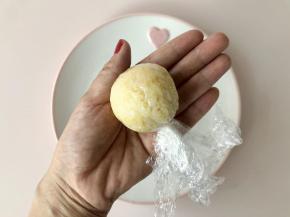 借助保鲜膜把杂粮饭团起，包住肉松，揉成圆球形。