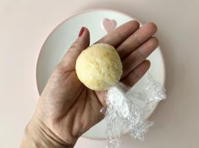 借助保鲜膜把杂粮饭团起，包住肉松，揉成圆球形。