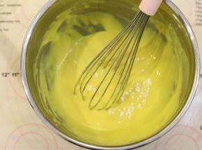 磕入蛋黄，手动打蛋器拌至顺滑的蛋黄糊，蛋清放入冰箱冷冻备用。