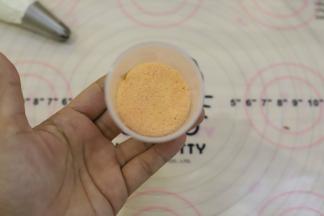 先将一块红色蛋糕片放入推推乐模内，压到最下面。