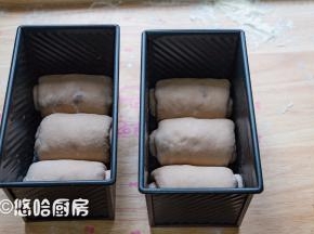 醒发后的面团进行二次擀、卷，卷起的面团放入吐司模具中。模具放入烤箱或密闭的容器中，里面放一碗热水，进行二次醒发。
