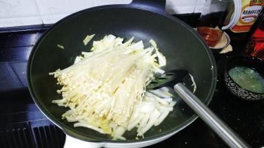 放入金针菇炒至软淋