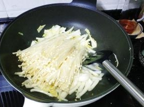 放入金针菇炒至软淋