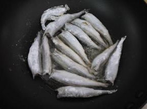 锅烧热，然后加入花生油，加热至7成热。把挂好粉的多春鱼逐一放进锅里，中火煎至鱼的一面定型。煎鱼时不要乱翻动，要先把一面煎成金黄色再翻面。