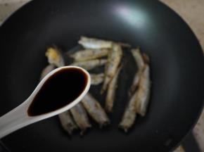 鱼煎好后调小火，然后进行调味，加入一勺酱油。稍微煮1分钟。