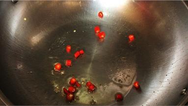 锅留底油，红辣椒入锅翻炒出香味。