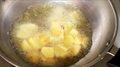 油温八成热，加入薯块炸制，中间翻动两次，让薯块受热均匀。